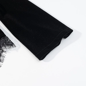 Detail of black velvet sleeve with delicate eyelash lace trim and textured finish