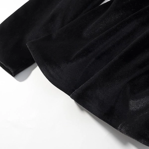 Dettaglio macro del velluto nero di un vestito con focus su texture morbida e lucentezza
