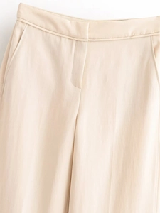 Détail du pantalon large crème montrant les coutures de la taille et les poches