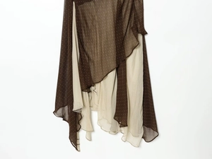 Detail of asymmetrical tiered skirt featuring polka dot pattern and sheer chiffon fabric