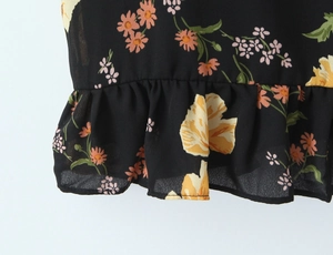 Detailed close-up of floral print chiffon fabric with ruffled hem and daisy patterns
