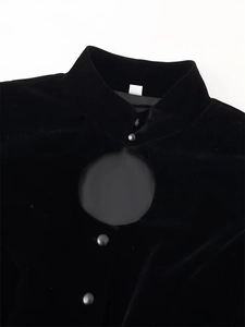 Close-up of velvet jacket with standing collar, keyhole neckline, and button detail