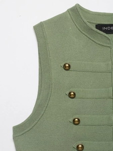 Detail of light green knit vest showing gold buttons and textured horizontal stripes