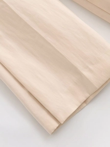 Détail de la texture du tissu tissé beige et des bords sans couture du pantalon large
