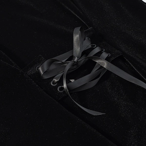 Detailed close-up of velvet garment with criss-cross dark grey satin ribbon lacing