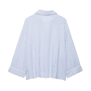 Detail of blue and white vertical stripes on loose fit long sleeve button shirt