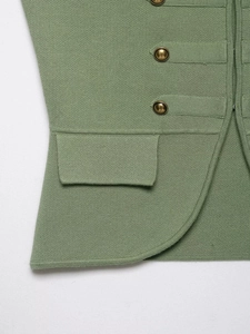 Macro detail of grass green knit vest featuring vintage gold metal buttons and pocket flap