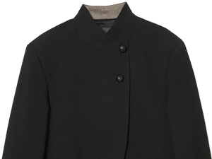Detailed view of the black stand collar and embossed buttons on a textured blazer