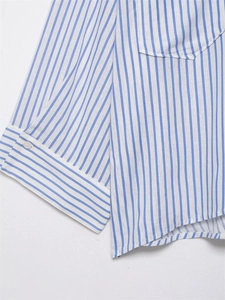 Detailed macro view of the white button and vertical stripes on a blue cotton shirt cuff