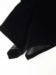 Detail shot of black velvet fabric with smooth lining and neat stitching on the hemline