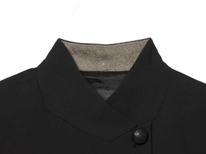 Detail of grey felt undercollar with diamond stitching and embossed crest button