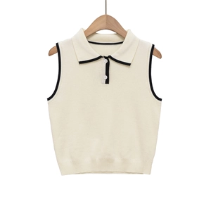 Detail of knit polo vest featuring black contrast piping and classic double button collar