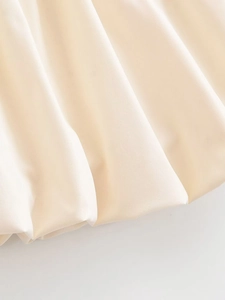 Gros plan sur le tissu plissé beige avec des plis verticaux élégants sur la jupe