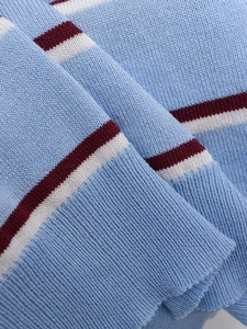 Detail view of the fine knit texture and striped pattern on the short-sleeved top