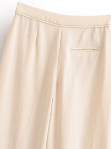 Gros plan détaillé du pantalon beige avec poche arrière passepoilée et finitions soignées