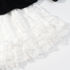 Abito alla moda con patchwork in velluto nero e dettagli in pizzo floreale bianco