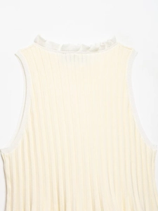 Macro detail of creamy white ribbed knit fabric with delicate lettuce edge trim