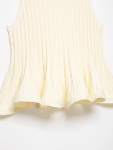 Detail of ribbed knit beige top showing the soft ruffled hemline and textured fabric