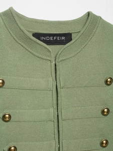 Close-up of green knit vest featuring textured fabric and vintage gold metal buttons