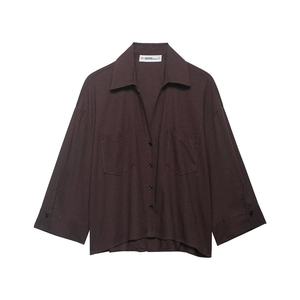 Detail of dark brown long-sleeve shirt with lapel collar and symmetric utility pockets