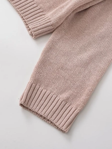 Close-up of pink knit sweater showing fine texture and ribbed cuffs for women