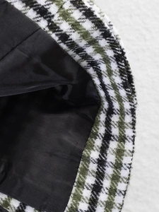 Detail shot of green and black houndstooth wool fabric with premium black inner lining