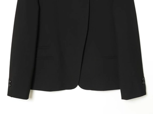 Detailed close-up of a black blazer hem featuring neat stitching and decorative cuff buttons