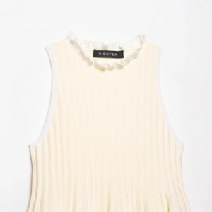 Sleeveless rib-knit top in cream with high ruffle neckline and flared hemline