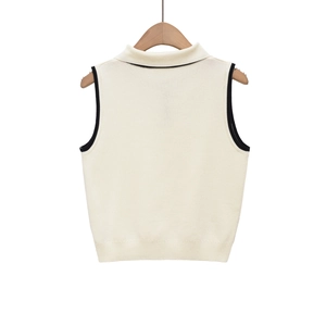 Detail of knit vest with contrast trim on the collar, armholes and ribbed hemline