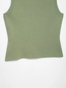 Detail of the light green knitted vest showing fine texture and ribbed neckline