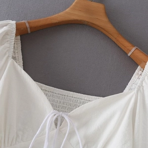 Weiße Baumwollbluse mit V-Ausschnitt, Smok-Details, langen Ärmeln und Bindeband