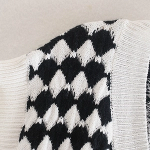 Chic black and white argyle knit vest with classic V-neck and ribbed edge details