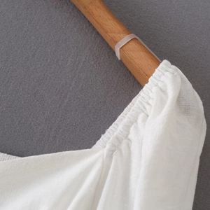 Nahaufnahme von weißem Baumwollstoff mit elastischen Plissee-Details und Textur