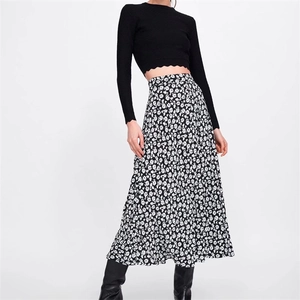Détail du haut en tricot noir à bord festonné et jupe midi à imprimé fleuri