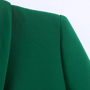 Detail of dark green blazer collar and shoulder showing fine fabric texture and stitching