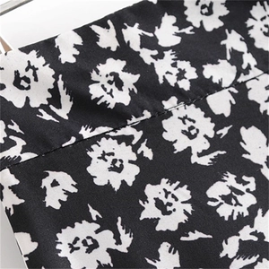 Détail du tissu de la jupe fleurie à taille haute avec motifs de fleurs noires et blanches