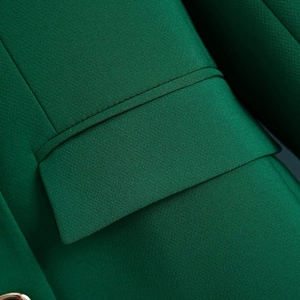 Macro detail of dark green blazer pocket showing precision double stitching and texture