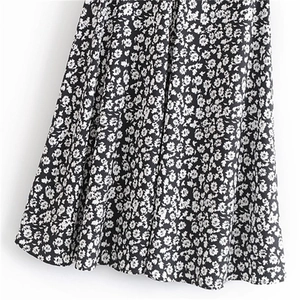 Détail de l'ourlet d'une jupe fleurie taille haute avec motif à petites fleurs noires et blanches