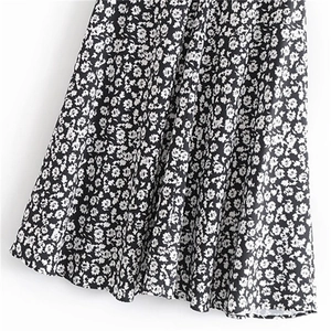 Détail de l'ourlet de jupe fleurie montrant l'imprimé blanc sur tissu noir