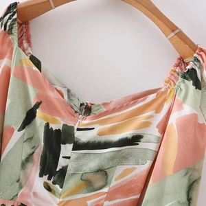 Detail of colorful abstract print dress featuring smocked neckline and invisible zipper
