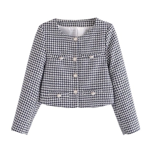 Detailed view of houndstooth jacket featuring pearl buttons and a classic round neck