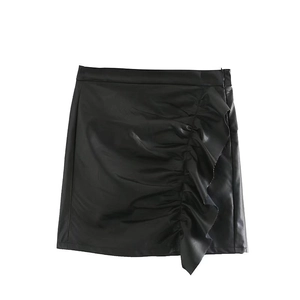 Detail view of the black faux leather mini skirt featuring elegant asymmetric ruffles