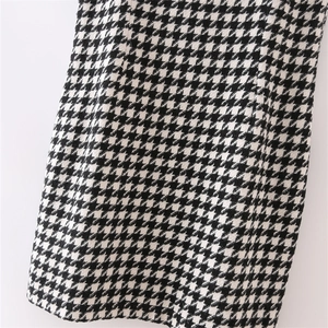Short sleeveless houndstooth tweed dress featuring classic black and white woven pattern