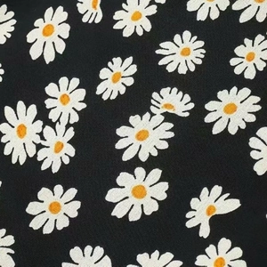 Detailaufnahme des schwarzen Gänseblümchen-Drucks mit Fokus auf Textur und Muster