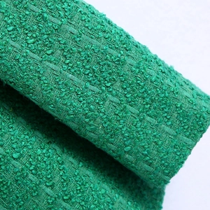 Close-up of green tweed fabric showing premium woven texture for a plaid blazer
