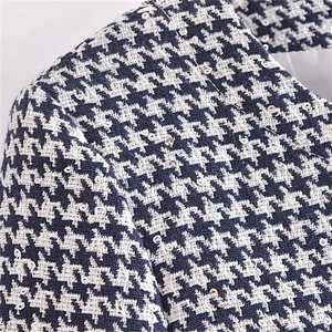 Detail of houndstooth tweed fabric with shimmering silver sequins and refined texture
