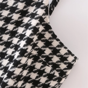 Close-up of black and white houndstooth wool fabric texture on short dress