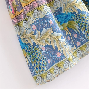 Close-up of cotton maxi skirt fabric featuring peacock and floral bohemian prints