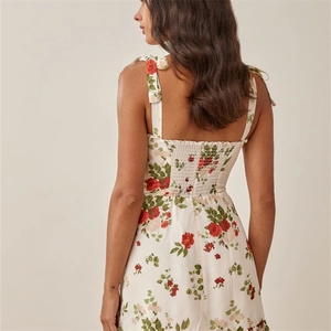 Detail of adjustable bow straps and smocked elastic back on floral summer midi dress