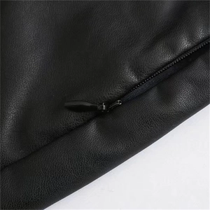 Detailed macro view of black faux leather texture and a hidden zipper on a waist skirt